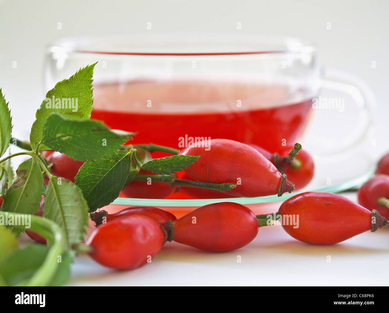 a glass cup with rose hip tea, in front are rose hip Stock Photo