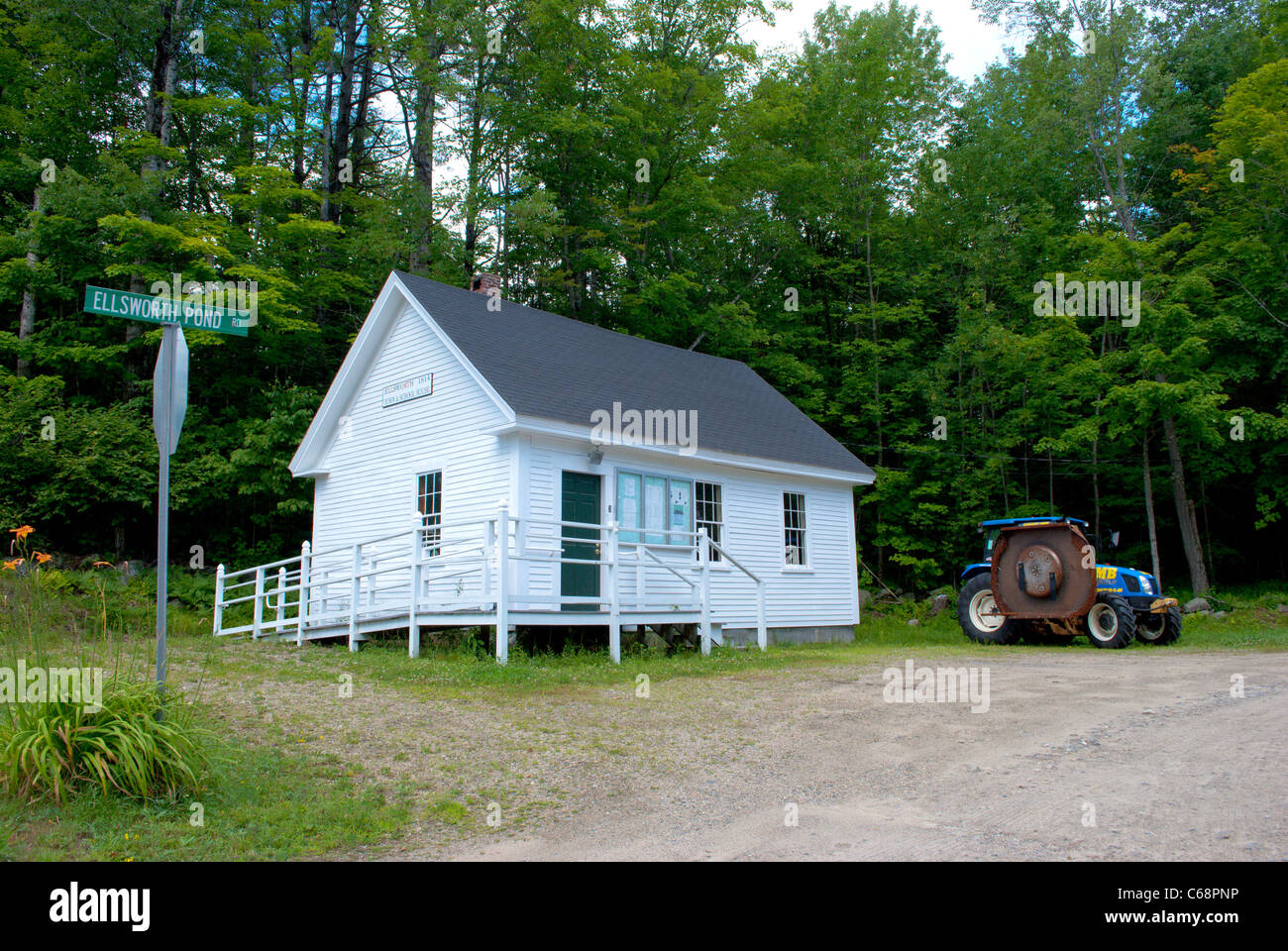 Small house in the woods with a tractor. Stock Photo