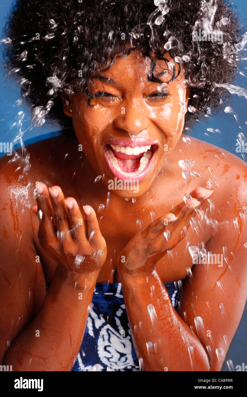 Cute African American splashes water to clean her face Stock Photo