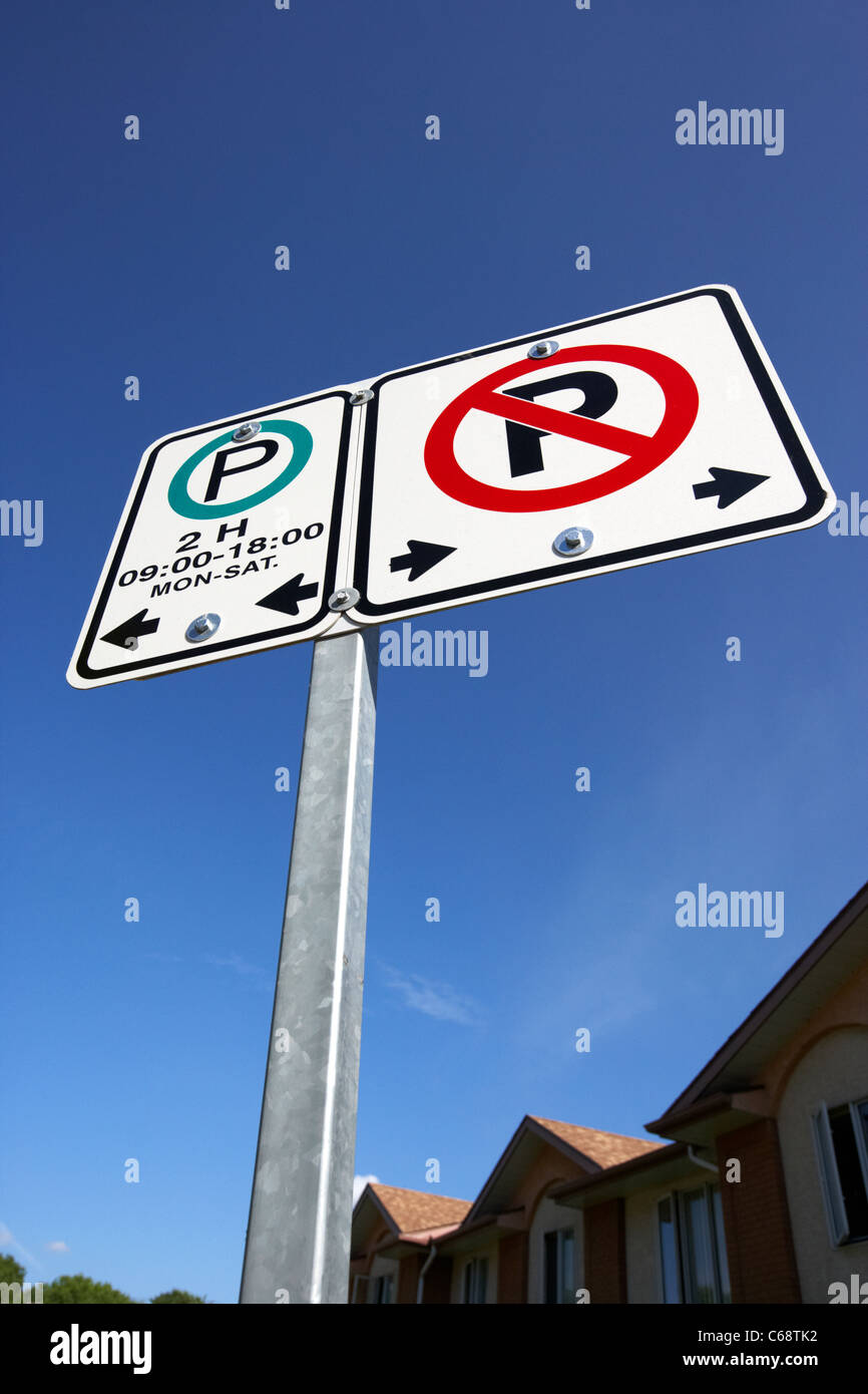 no parking parking restriction signs signposts against blue sky Saskatoon Saskatchewan Canada Stock Photo