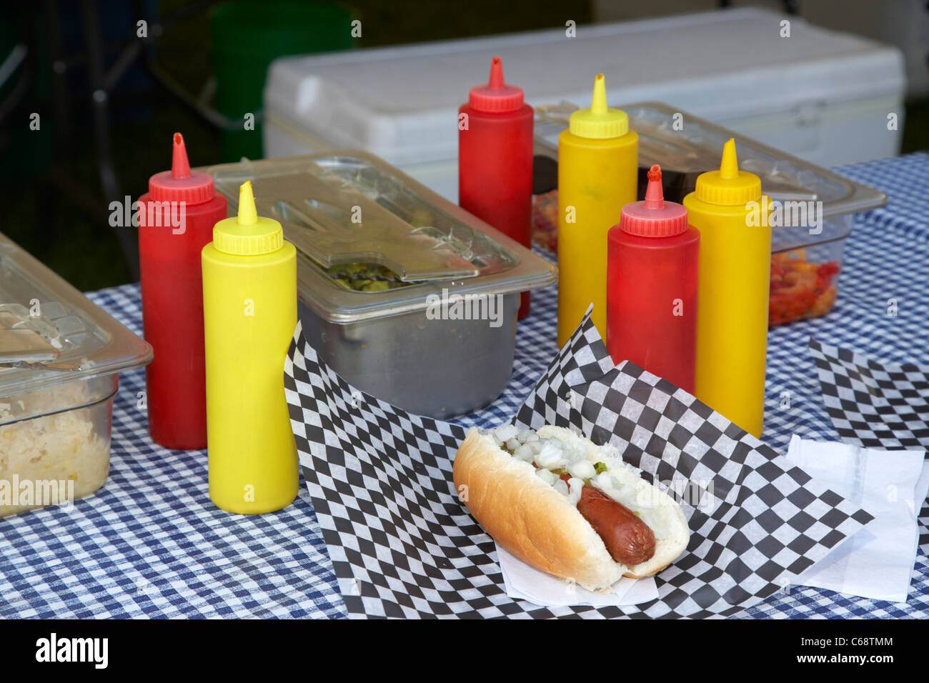 hotdog in bun with onions on a fast food stall at an outdoor event with ketchup and mustard Saskatoon Saskatchewan Canada Stock Photo