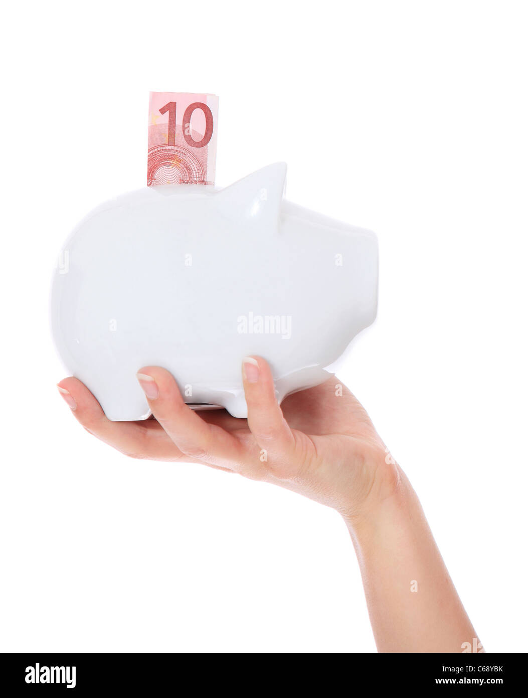 A persons hand holding piggy bank. All on white background. Stock Photo