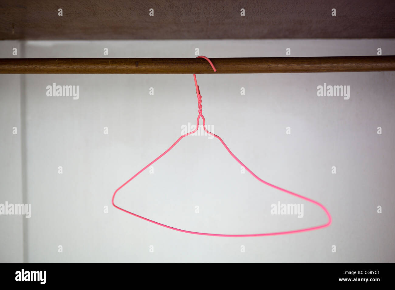 Pink Wire Coat Hanger in Wardrobe Stock Photo