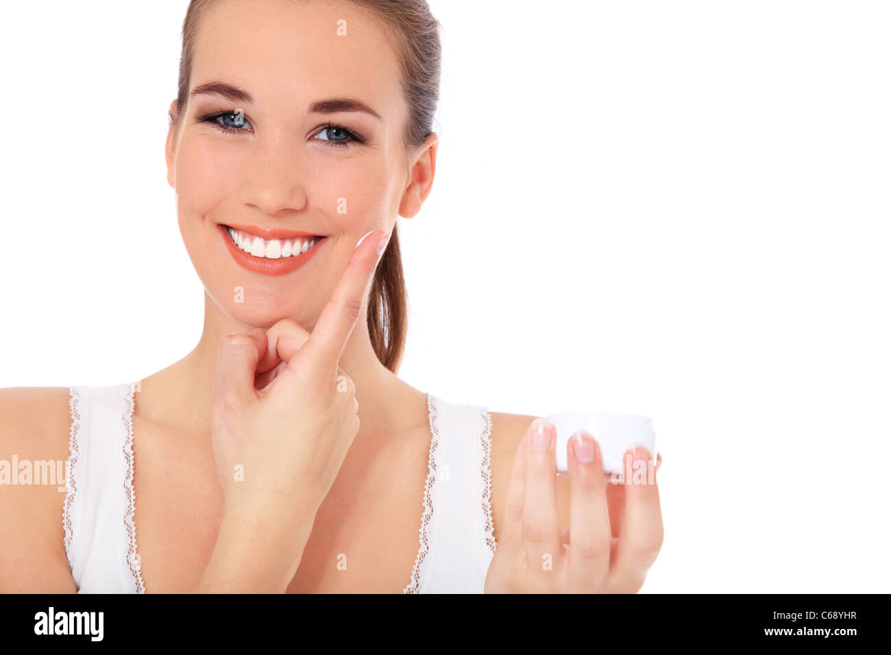Attractive young woman puts on some lotion. All on white background