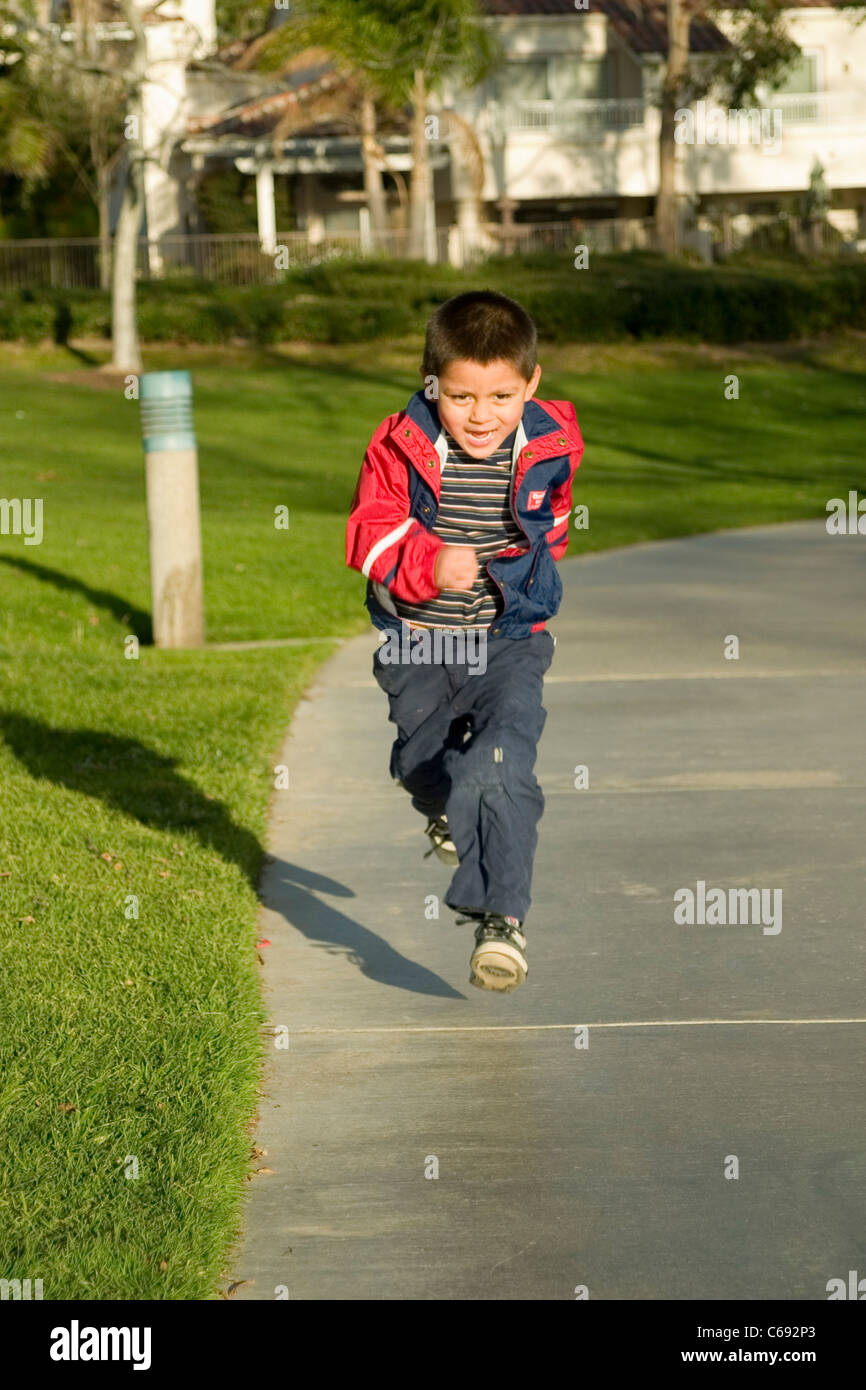 Happy energetic young Hispanic boy 4-5 year old years running at park sidewalk outside MR © Myrleen Pearson Stock Photo