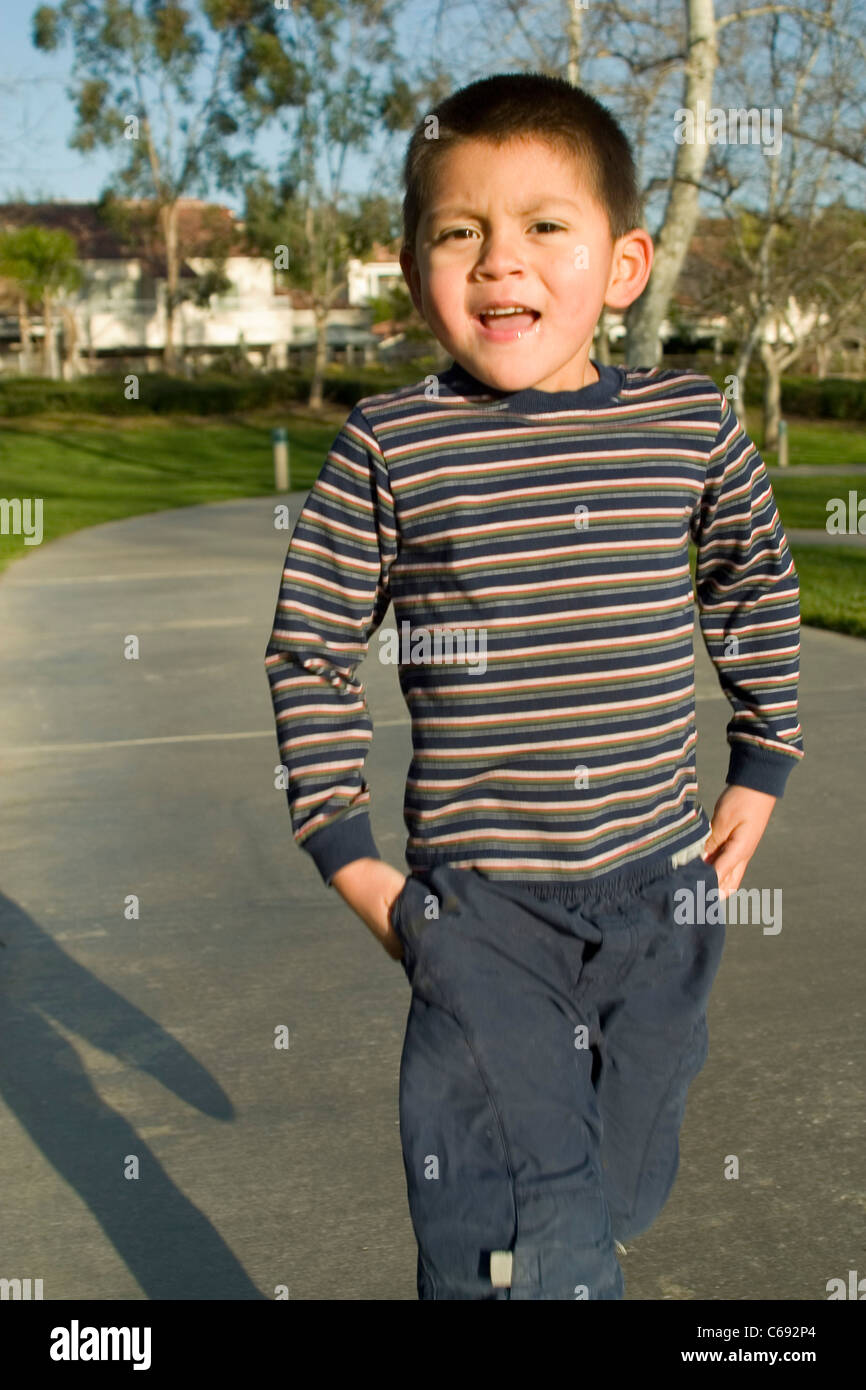 Cute extrovert personality Pre K 3-5 year old young close up Hispanic boy at park hand pocket hands in pockets  talking eye contact  MR © Myrleen Pearson Stock Photo