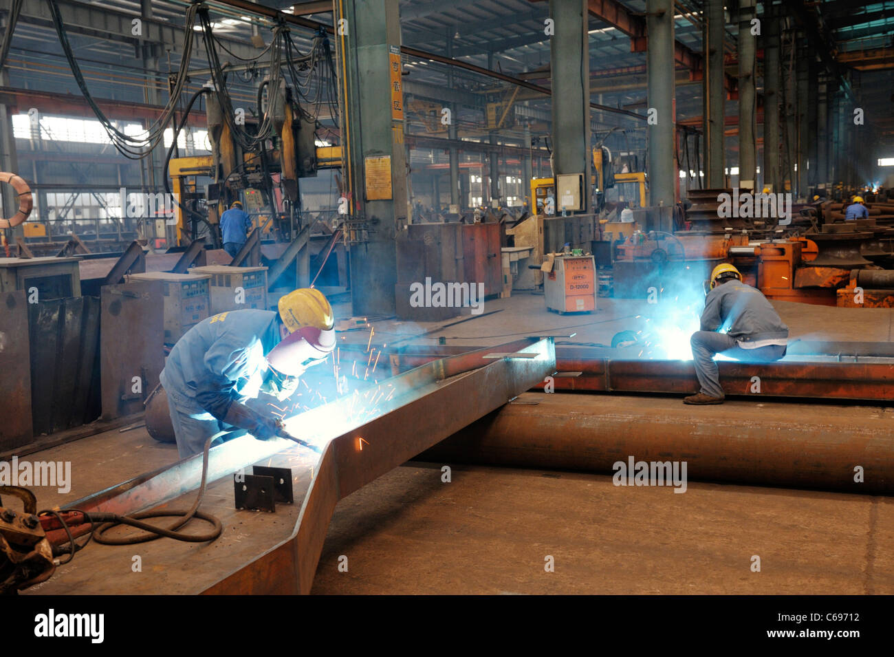 Hangzhou, Zhejiang, China. Welders and interior of one of the massive fabrication sheds of Triumpher steel works Stock Photo