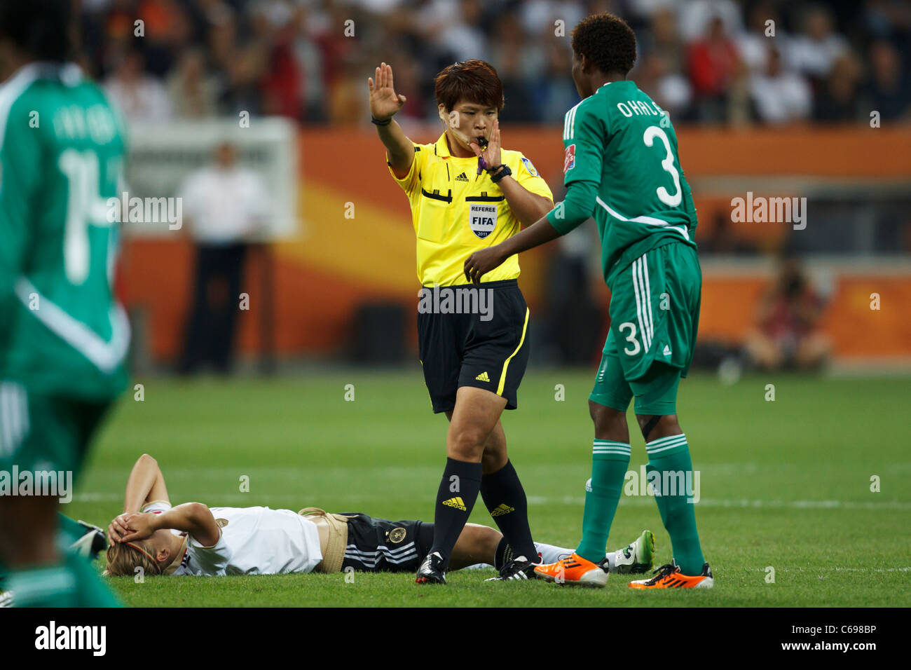 Referee Sung Mi Cha blows her whistle to call a foul on Osinache Ohale of Nigeria (3) during a 2011 Women's World Cup match. Stock Photo