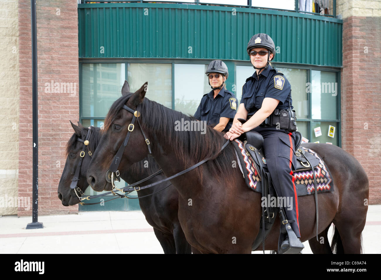 two female winnipeg police officers on horseback in Winnipeg Manitoba Canada Stock Photo