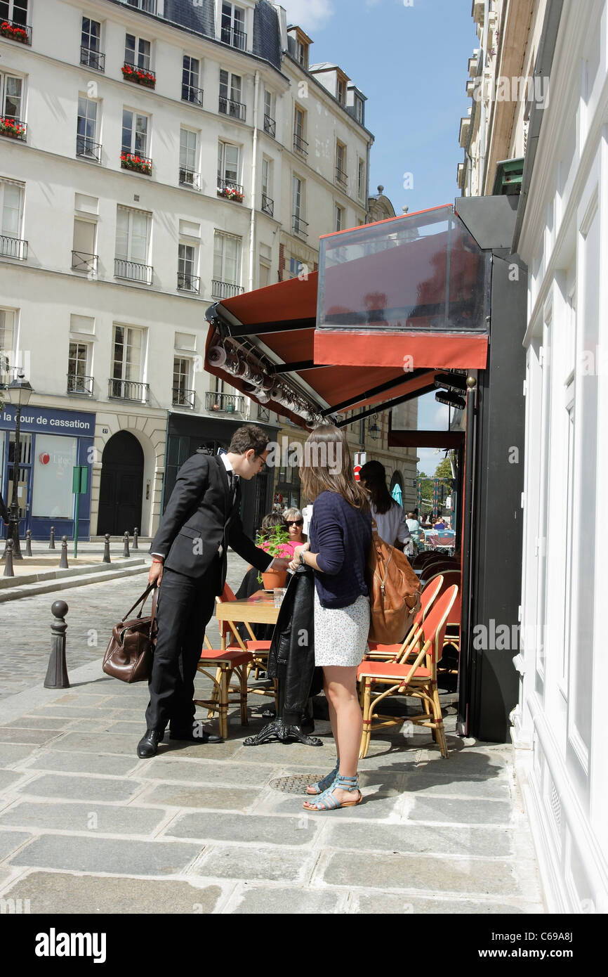 Customers leaving a pavement cafe in a quiet street in Paris, France
