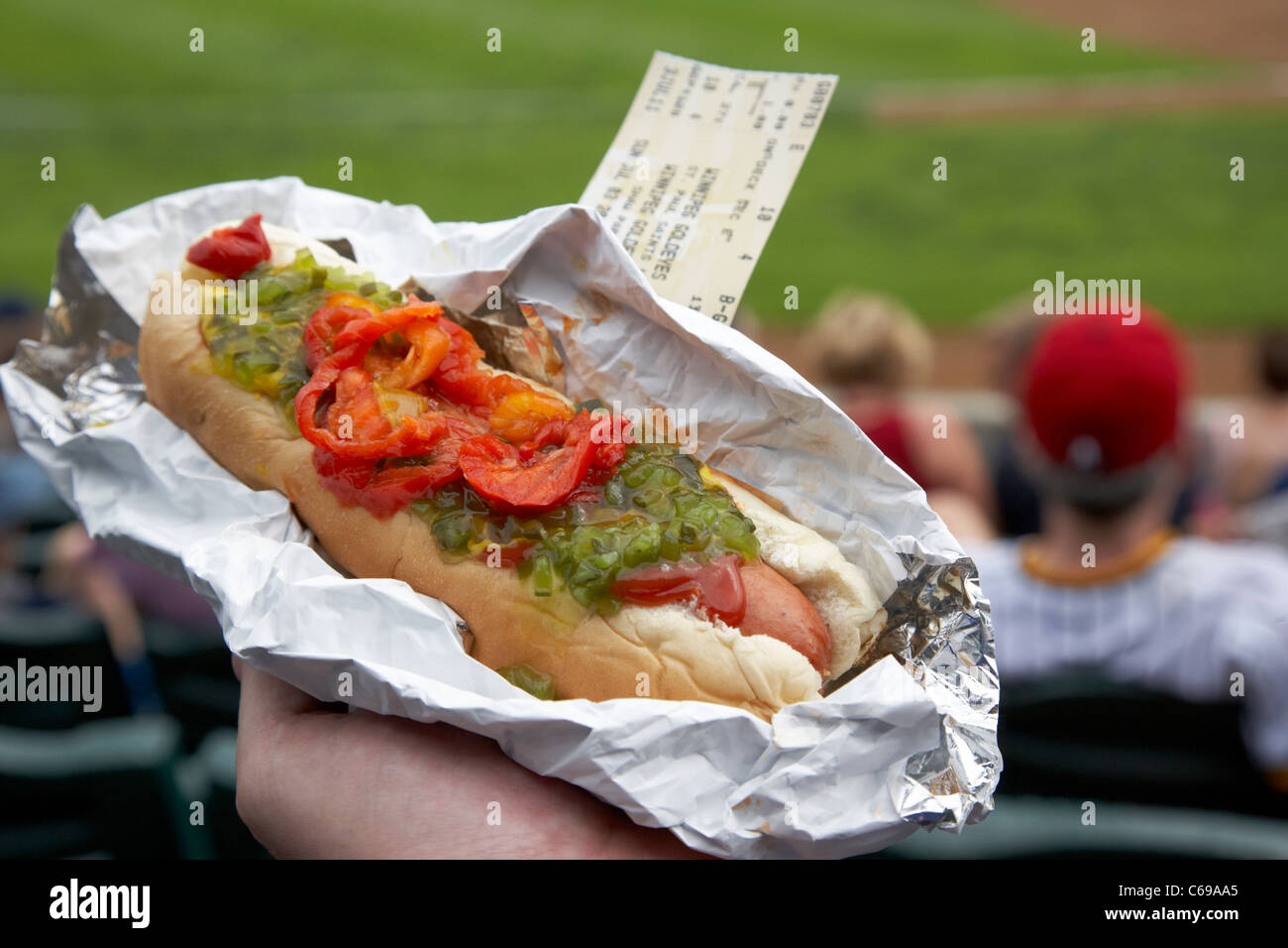holding hotdog and baseball ticket in stand at ballpark Winnipeg Manitoba Canada Stock Photo
