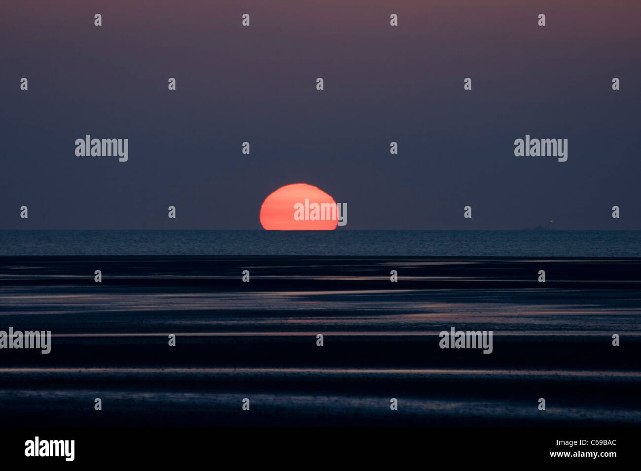 Sunset bright orange ball sinking Stock Photo Alamy
