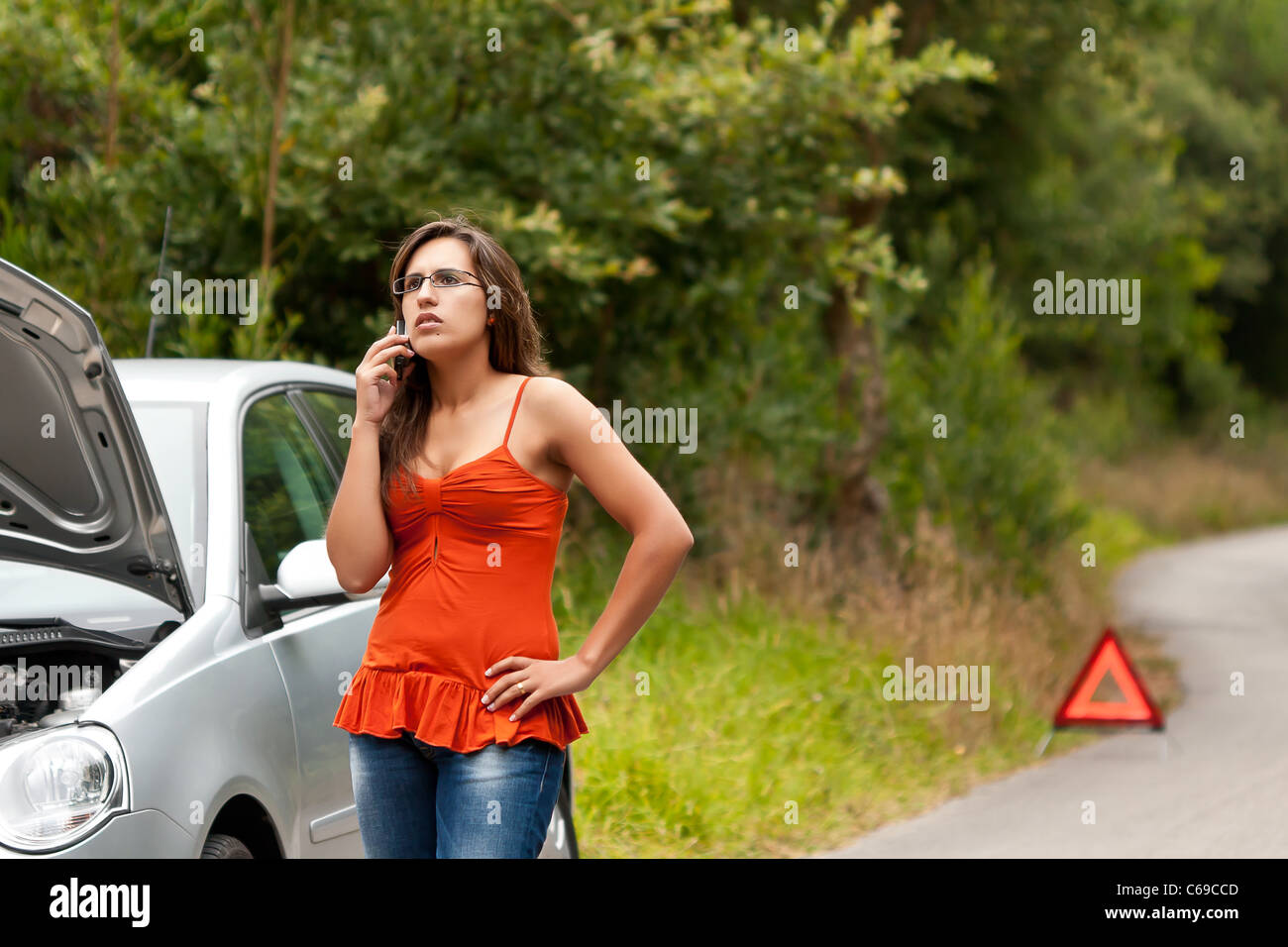 A woman calls for assistance using her mobile phone, after her car ...