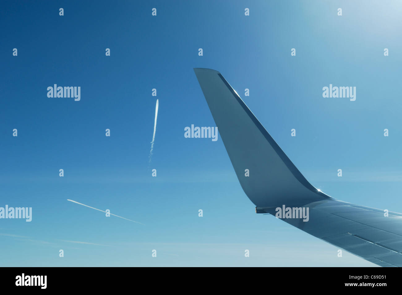 Plane wing with airliners fumes traces in blue sky, France Stock Photo