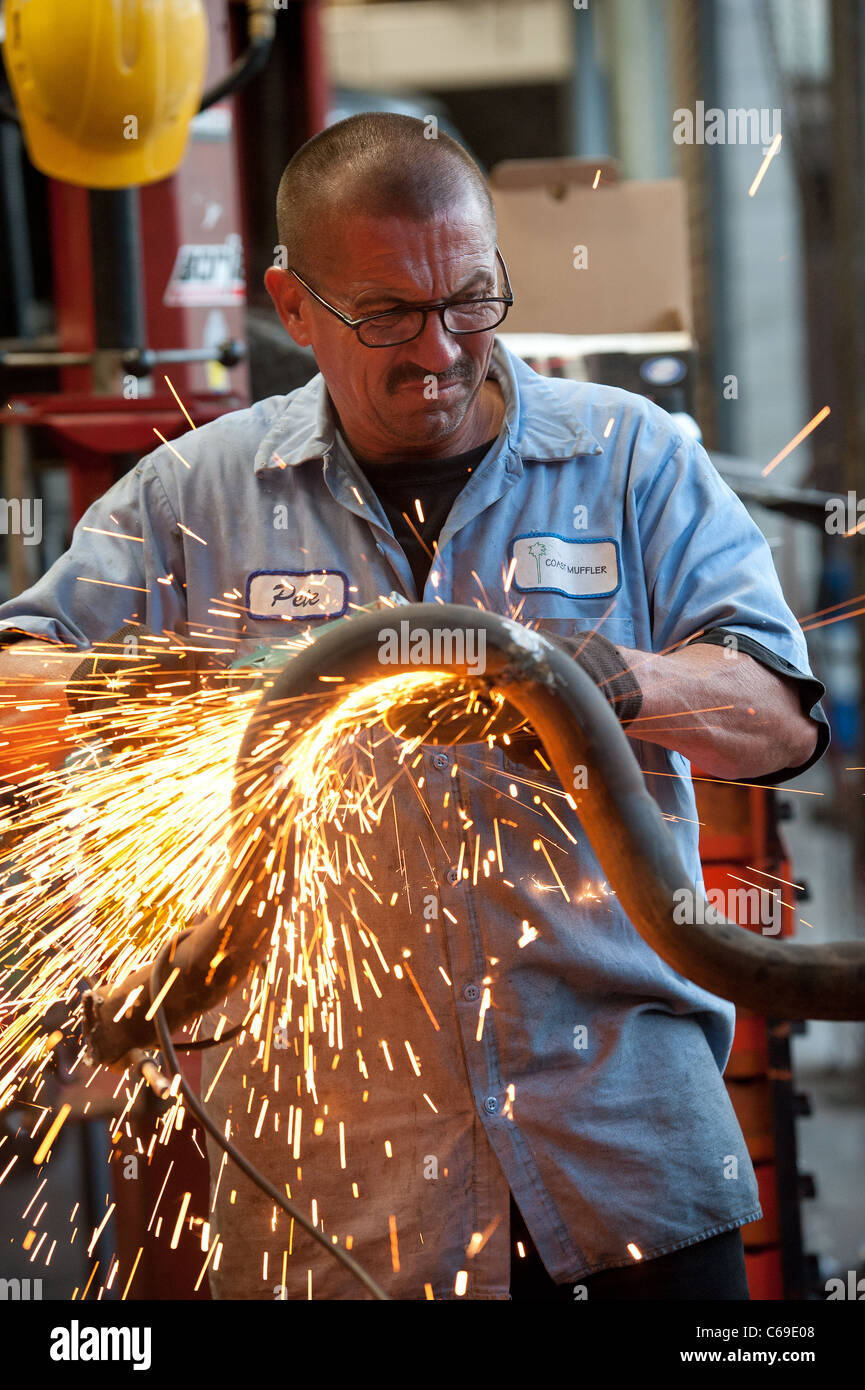 a Mechanic cuts a muffler pipe Stock Photo Alamy