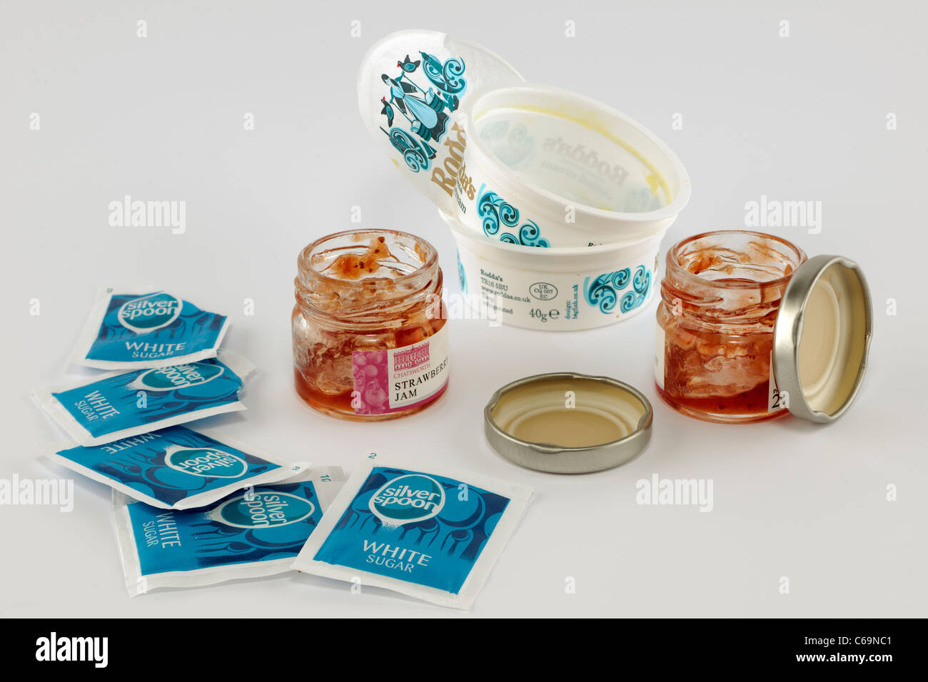 Opened and used 28 gram jam pots and cream tubs and sachets of sugar Stock Photo