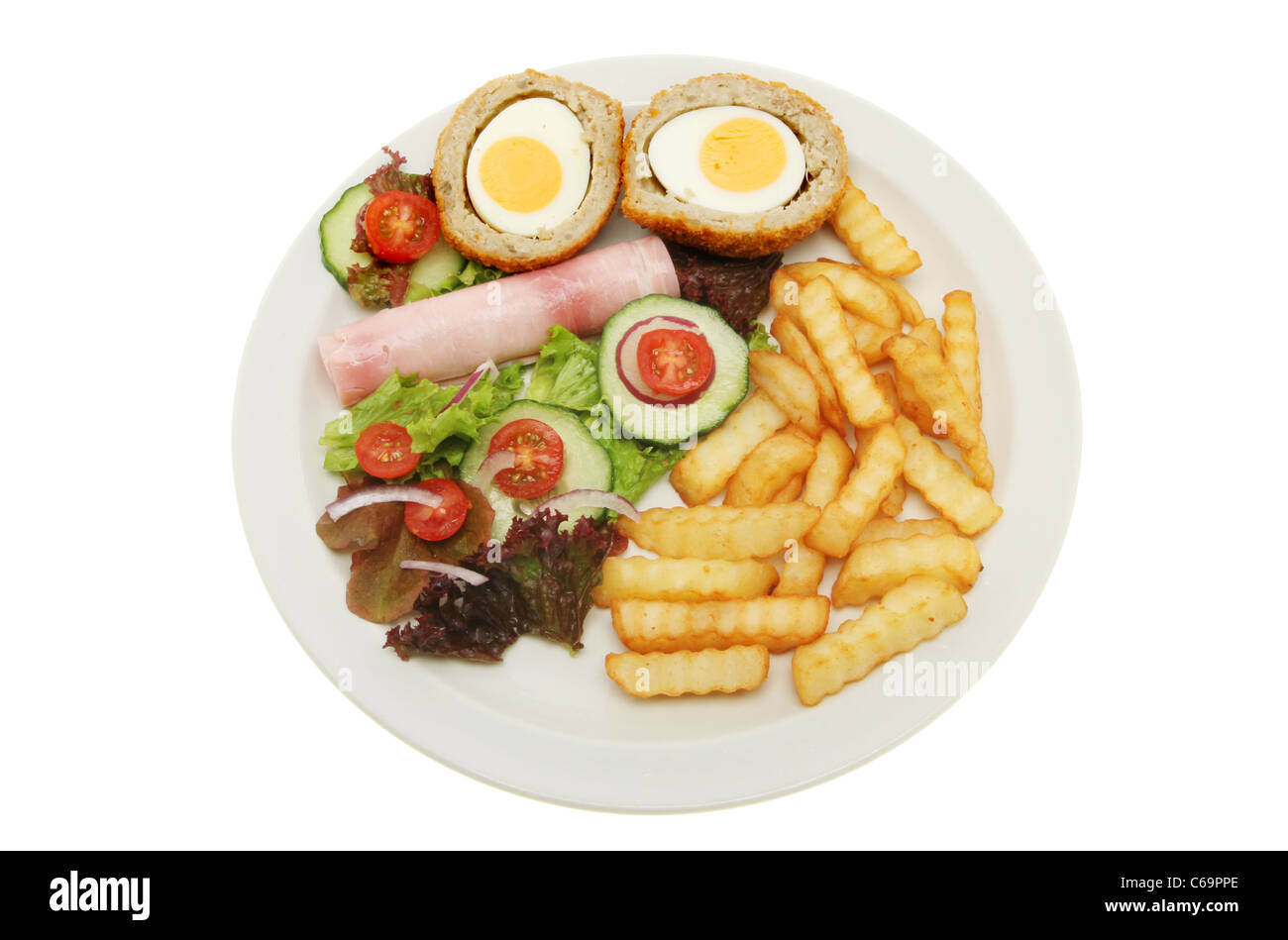 Scotch egg and ham salad with chips on a plate isolated against white Stock Photo