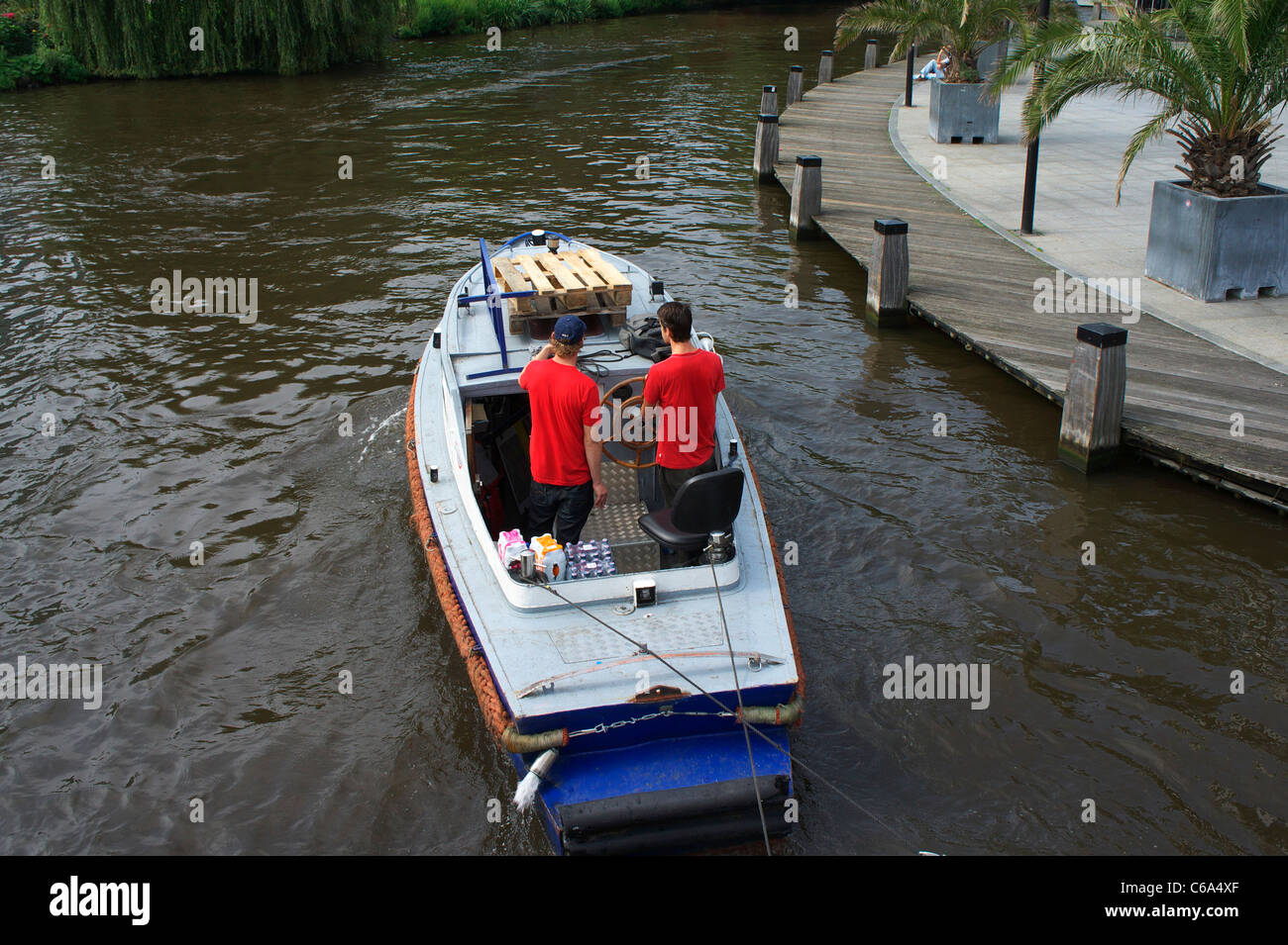 Motor boat towing pedalos on Singel Gracht in Amsterdam Stock Photo