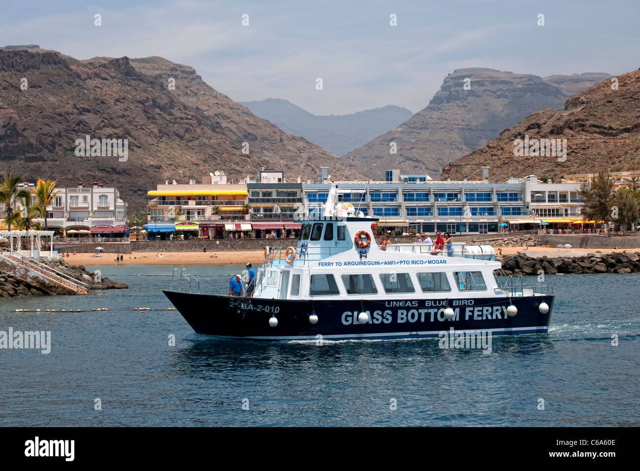 Glass bottomed boat ferrying tourists around the coast in the Puerto Mogan  area of Gran Canaria Stock Photo - Alamy