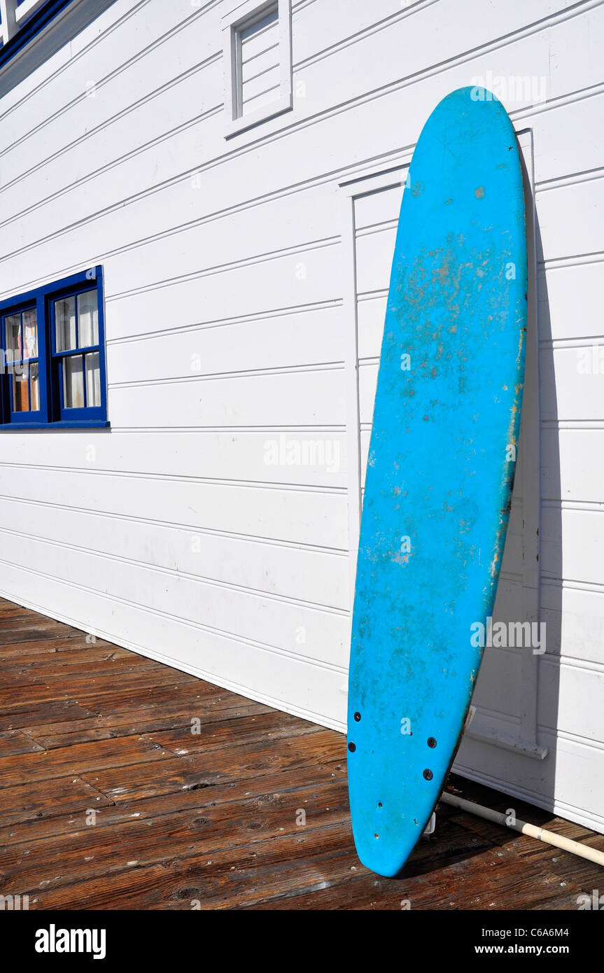 A blue surf board against a white wall Stock Photo