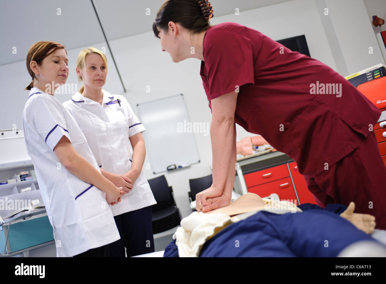 student nurses and teachers practicing resuscitation cpr on dummy patient in clinical skills lab Stock Photo