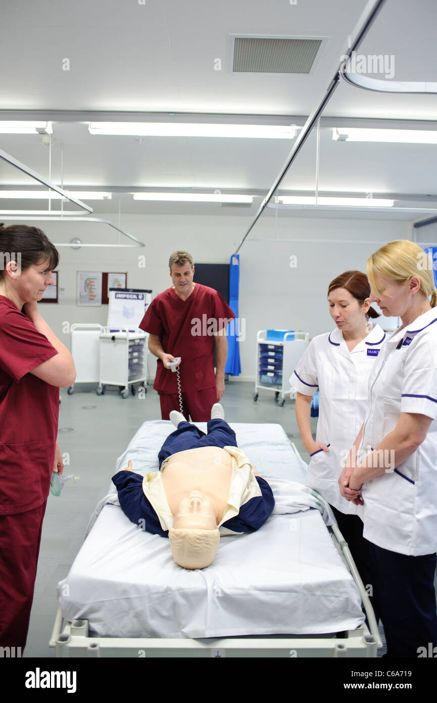 student nurses and teachers practicing resuscitation cpr on dummy patient in clinical skills lab Stock Photo