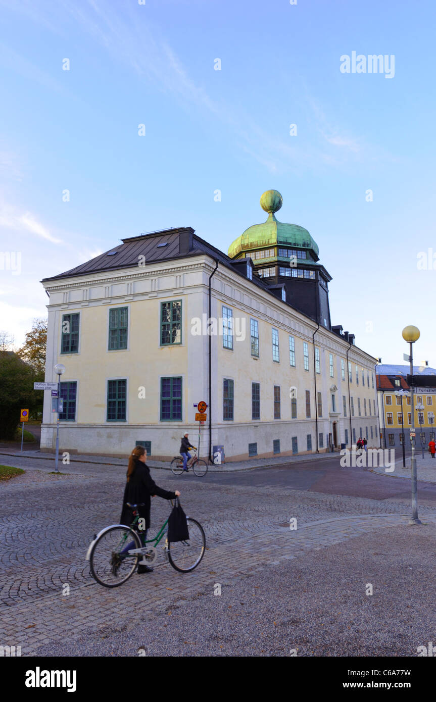 Gustavianum building Uppsala University, Sweden, Scandinavia. Old Swedish building; Scandinavian person with bicycle on cobbled street; historic Stock Photo