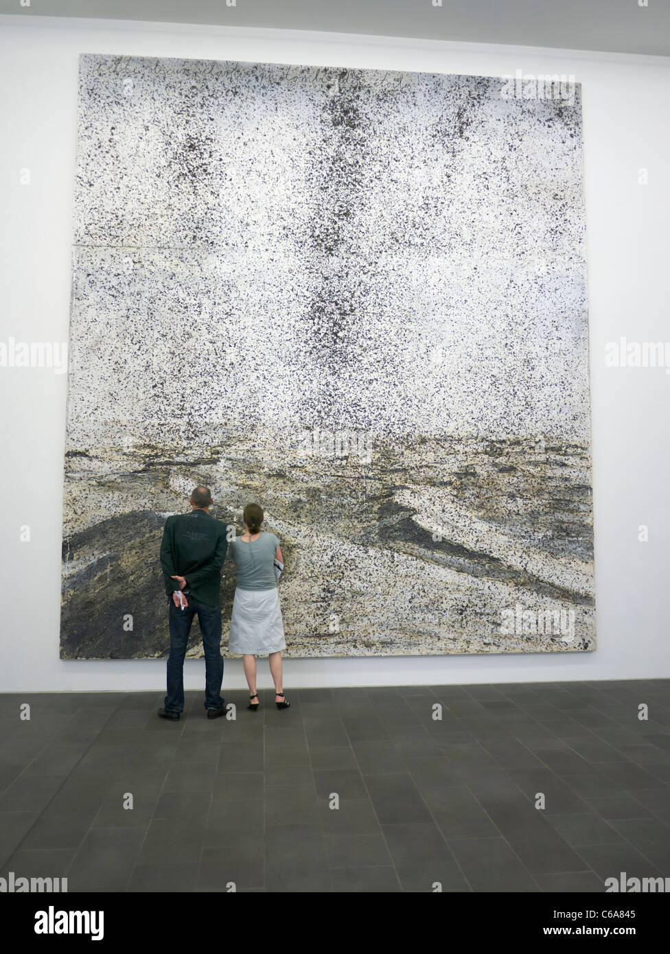 Looking at Painting Cette Obscure clarte qui tombe des etoiles by Anselm Kiefer at Kuppersmuhle Museum at Innenhafen area of Dui Stock Photo