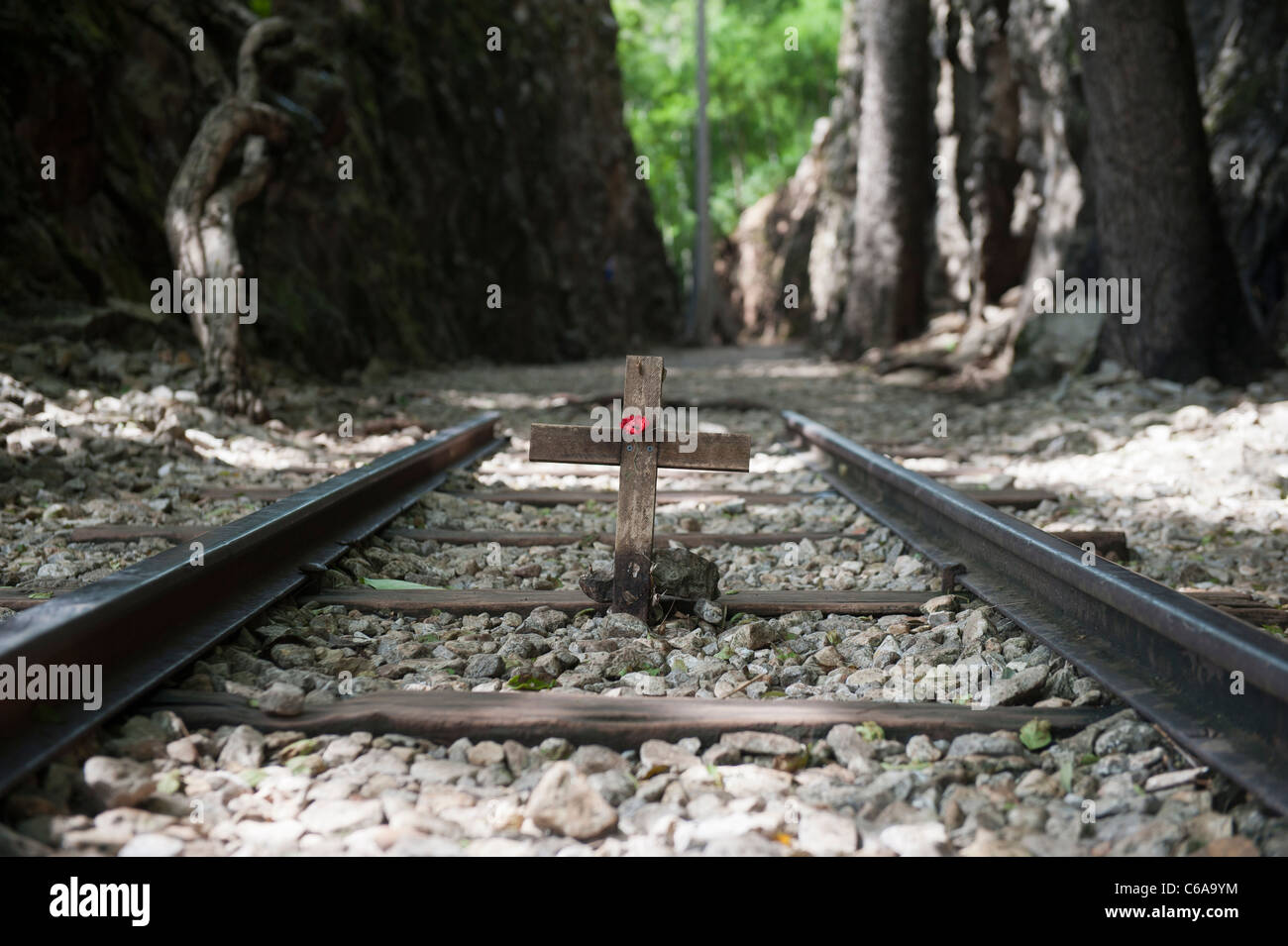 Remembrance wooden cross and red poppy along a section of railway at Hell Fire Pass railway cutting Kanchanaburi Thailand Stock Photo