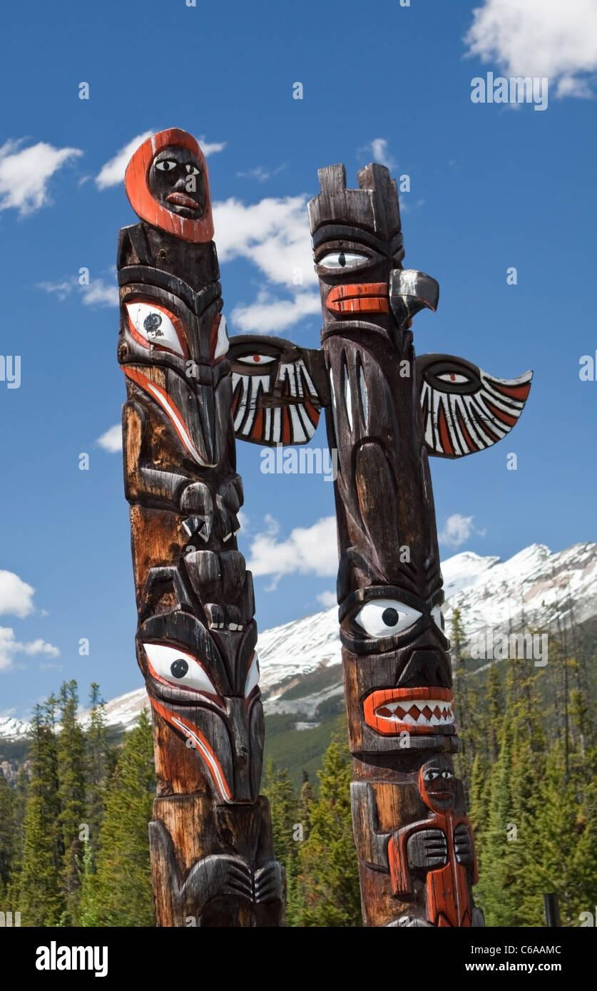 Totem Poles Canada with Rocky Mountains in Background Stock Photo