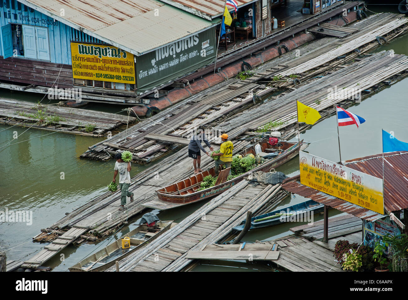 Unloading bananas at a floating village on the river Songaria, in Sangkhlaburi, Kanchanaburi province Thailand Stock Photo