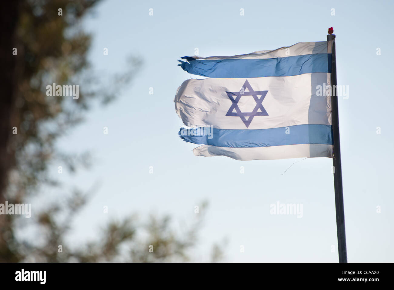 A ragged Israeli flag flies over the Jewish settlement of Beit Hoshen on the Mount of Olives in East Jerusalem. Stock Photo