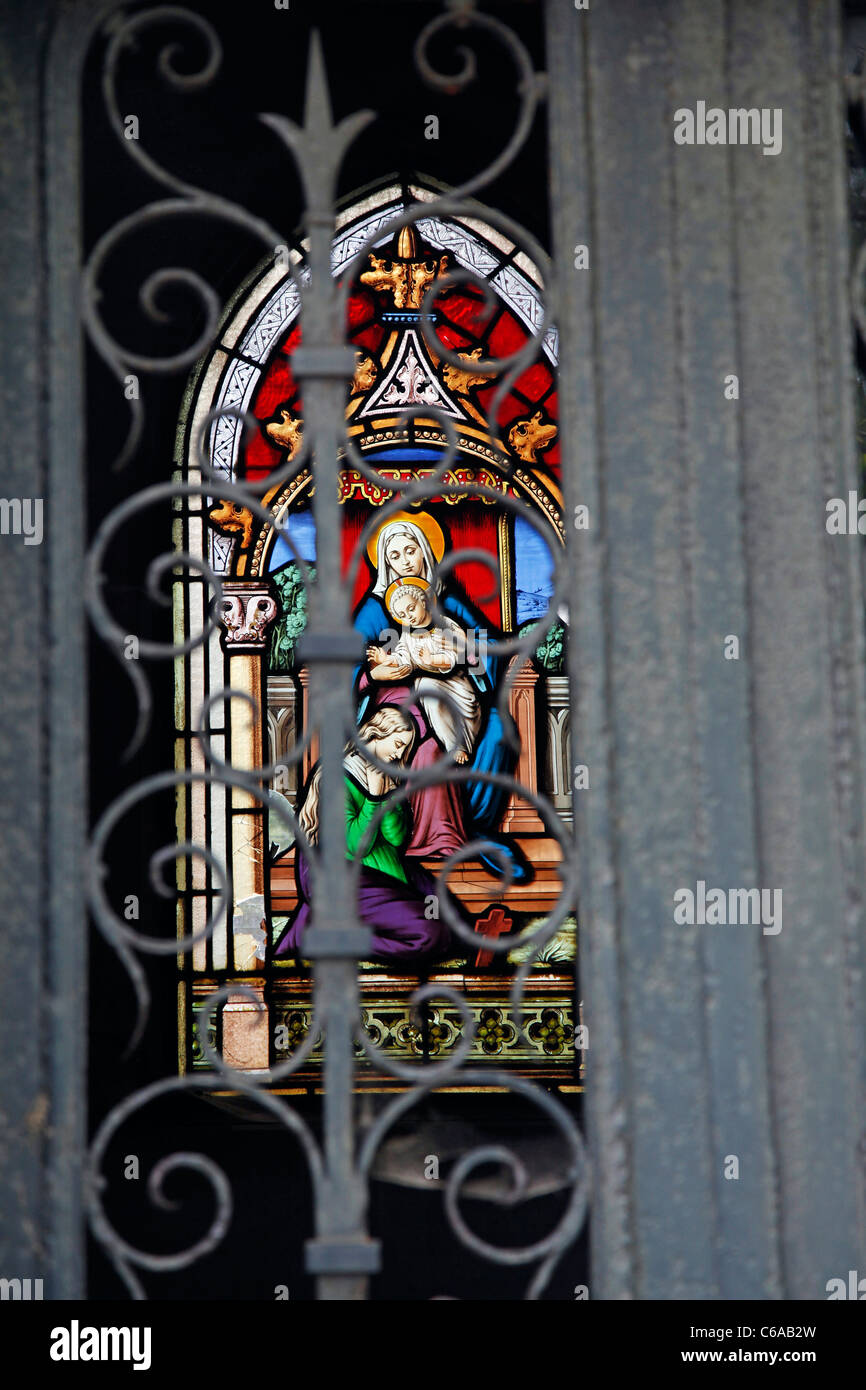 Stained glass window on a grave or mausoleum in the graveyard at the