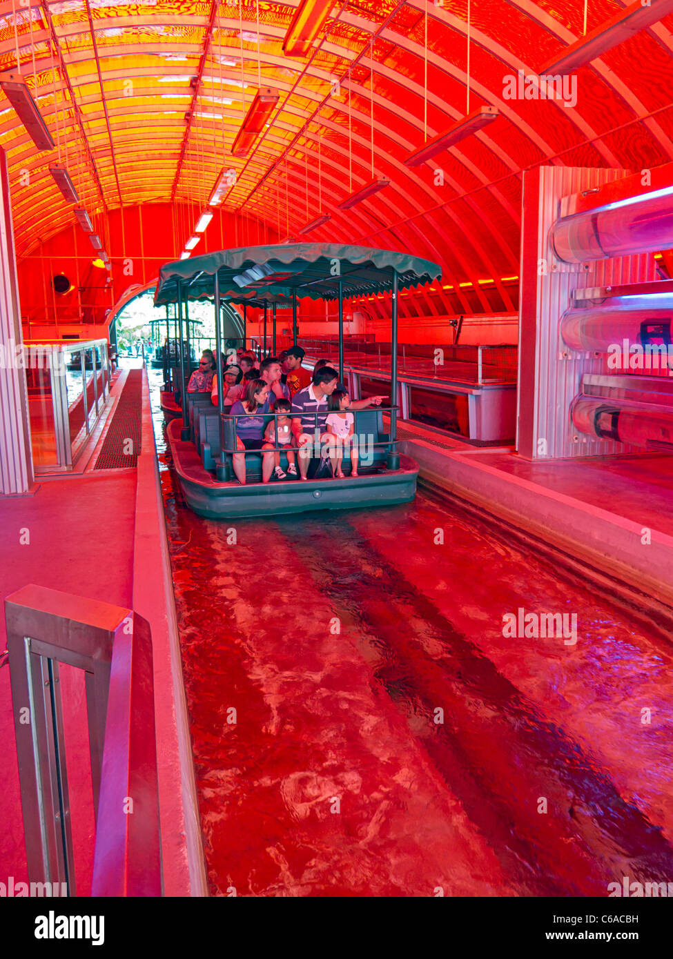 Tourists in a boat travel through fish farm at Disney World's Living