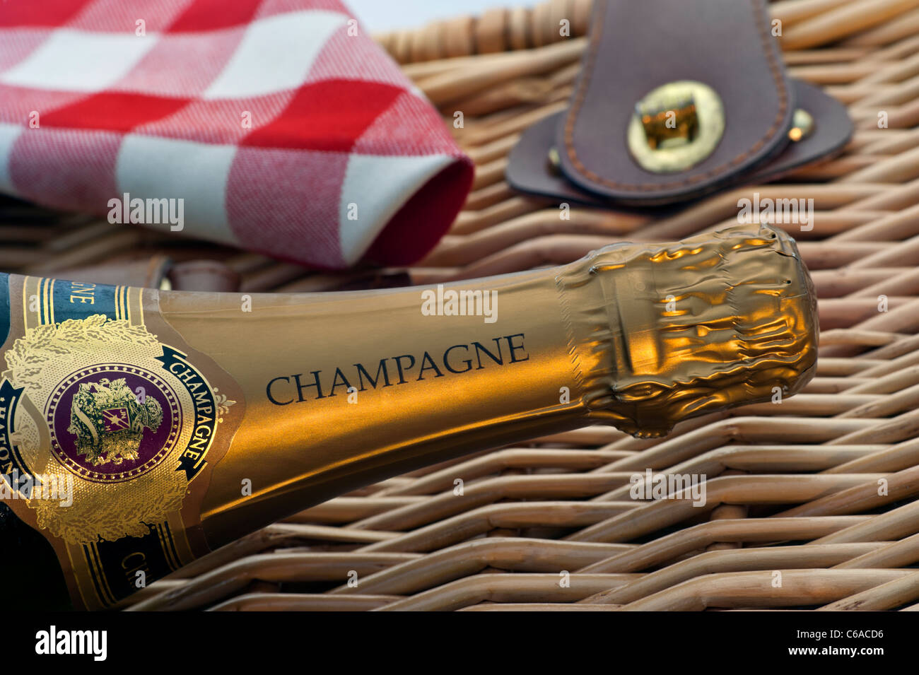 Champagne bottle on wicker picnic hamper at luxury alfresco summer event picnic situation Stock Photo