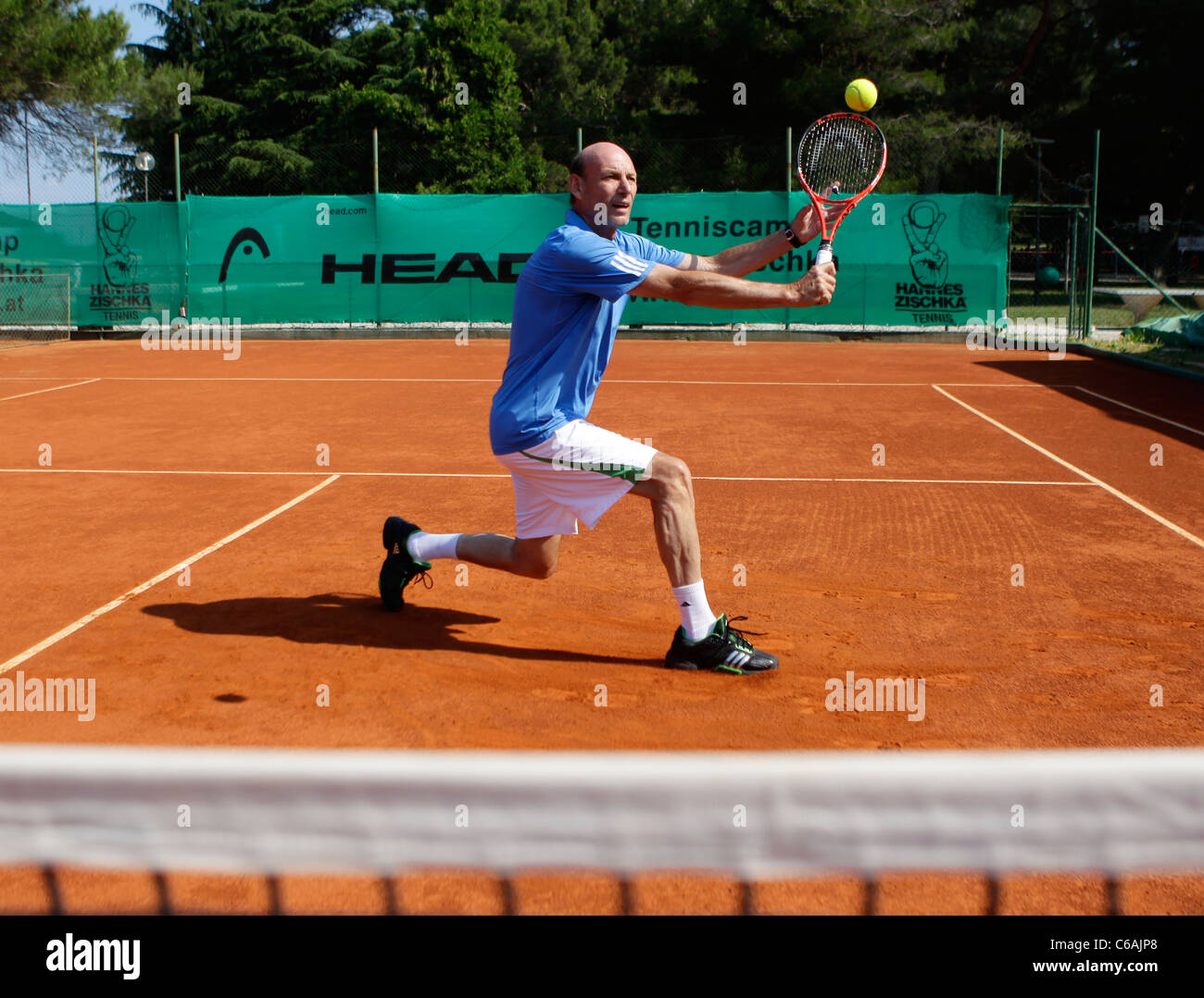 Tennis player in action at the net Stock Photo