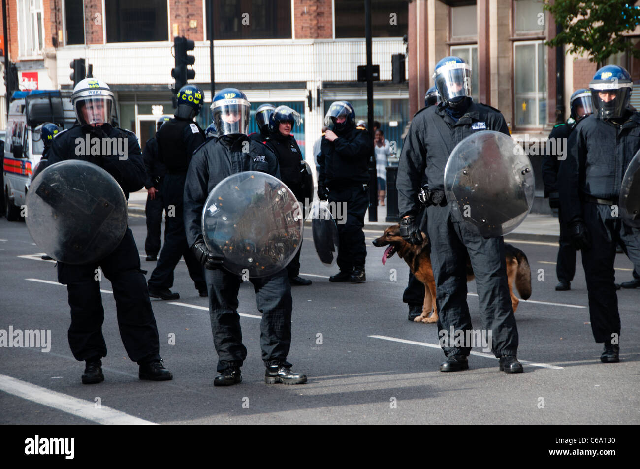 Riot police  with helmets and riot shields and an Alsatian dog on Mare street Hackney during the August 8th 2011 riot Stock Photo