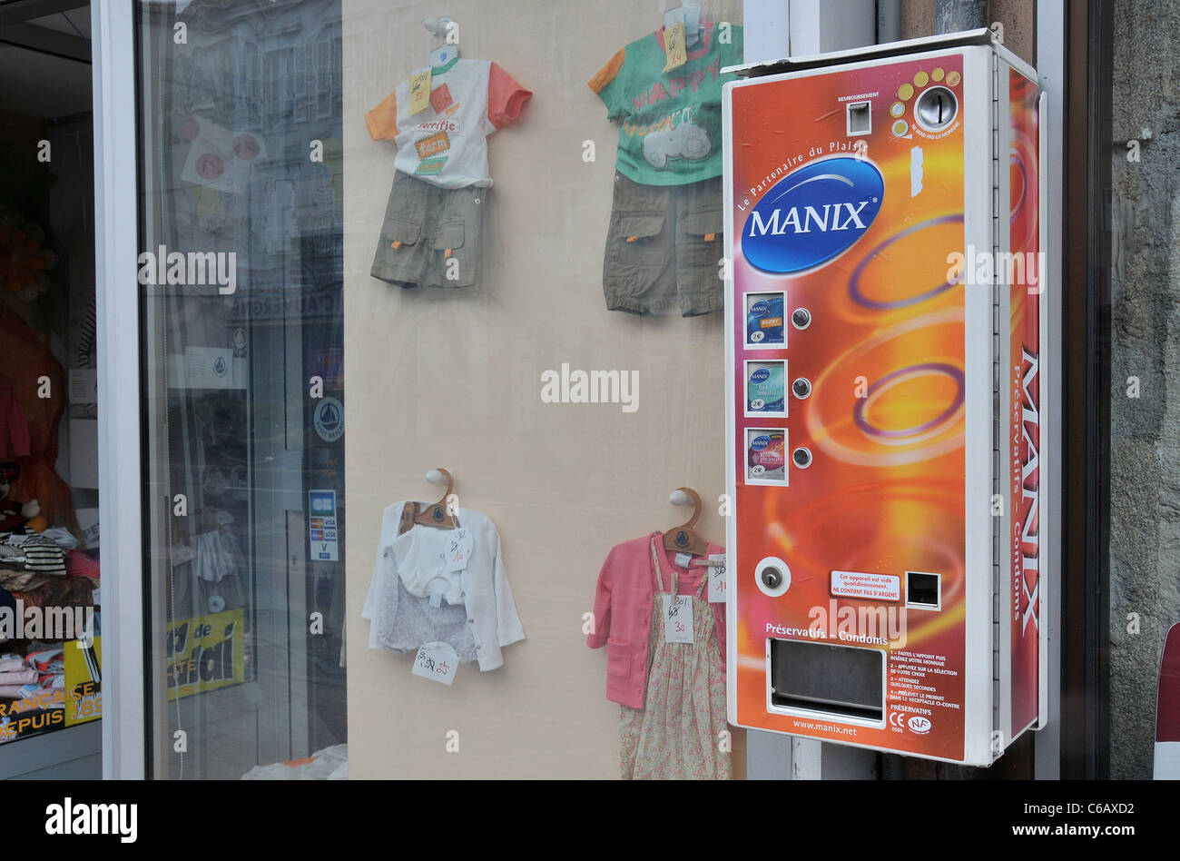 condom vending machine next 'Baby Luxe' store (baby  clothes specialized), Issoire, Auvergne, France Stock Photo