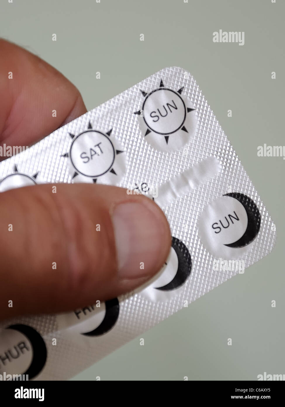 Holding medication in sealed foil packaging. Stock Photo