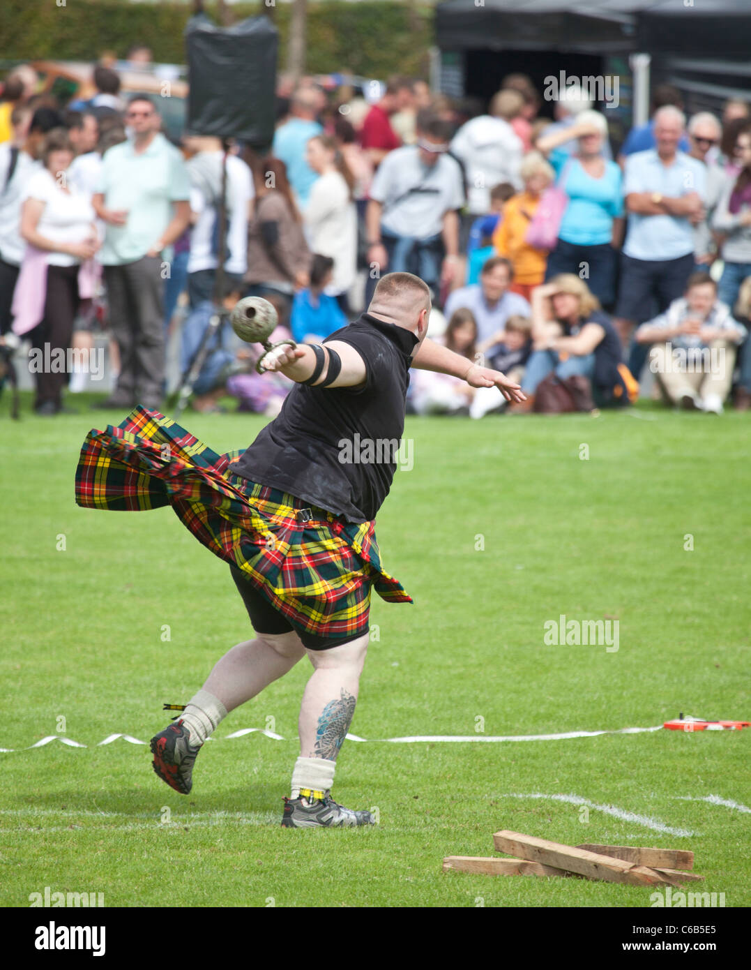 Kilted athlete in the 'throwing a 28lb' competition weight during one