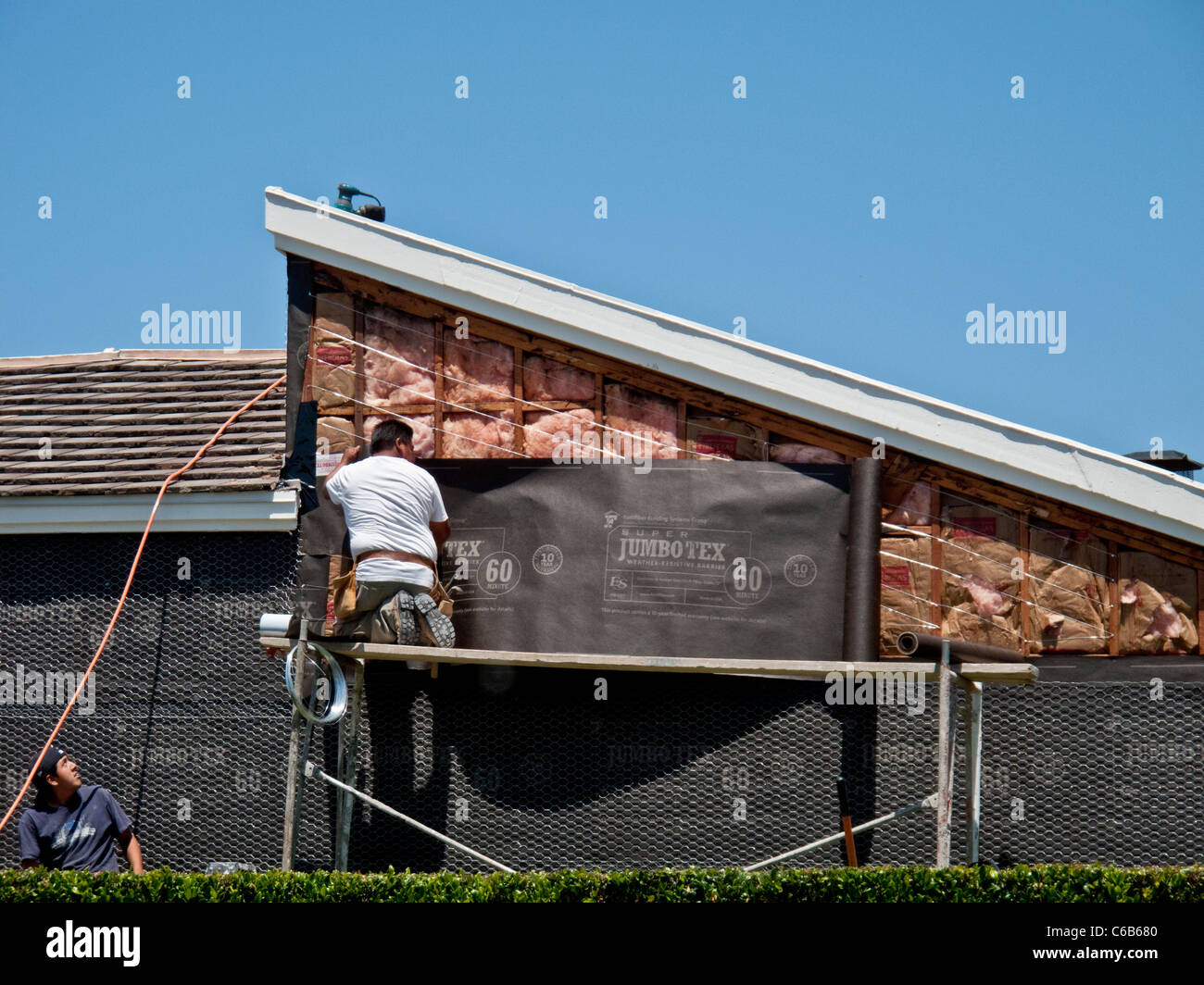 Hispanic workmen install tarpaper on a home exterior in Laguna Niguel ...