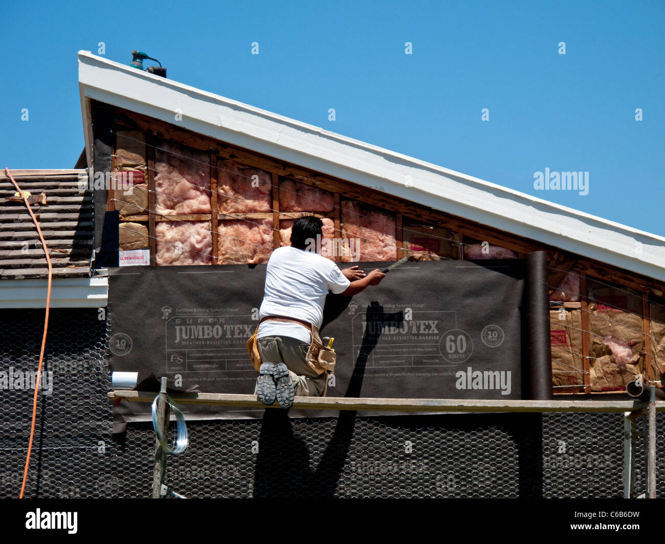 Hispanic workmen install tarpaper on a home exterior in Laguna Niguel ...