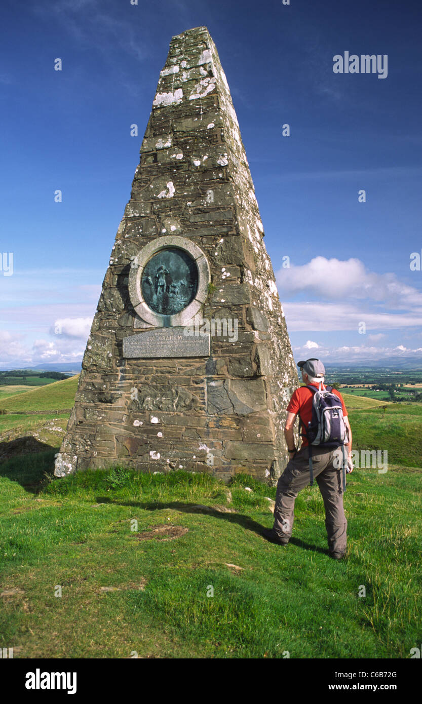 Hill walker walking the Annandale Way on Almagill Hill looking up at Joe Graham's Monument Dalton Scotland UK Stock Photo