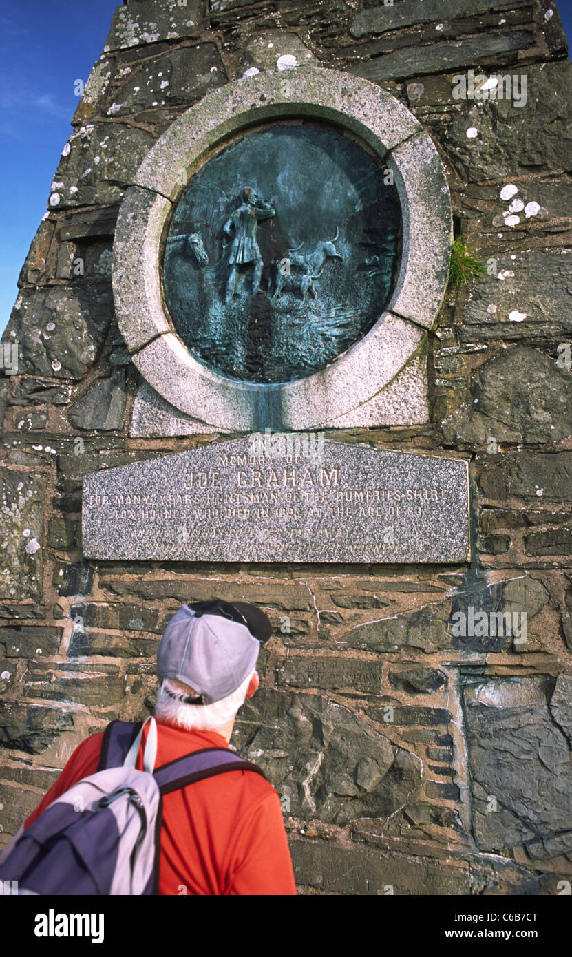 Hill walker walking the Annandale Way on Almagill Hill looking up at Joe Graham's Monument near Dalton Scotland Stock Photo