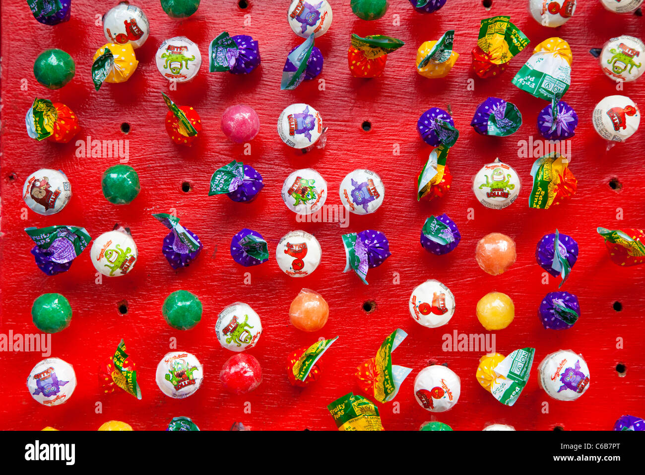 Wrapped sweet lollies on a red board Stock Photo