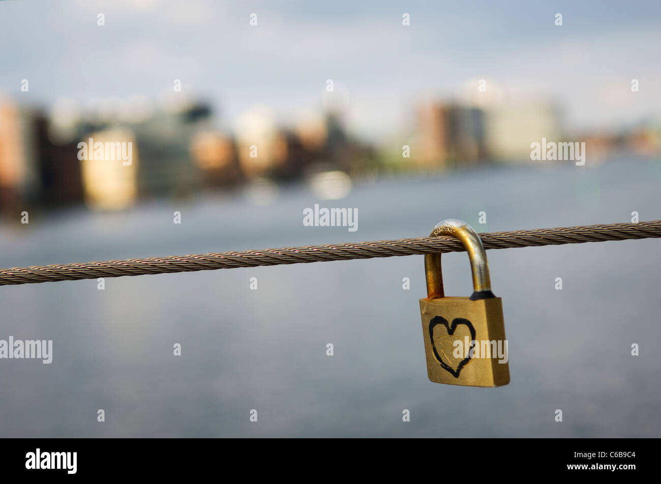 Love lock with heart in Copenhagen, with the financial district in the background. Stock Photo