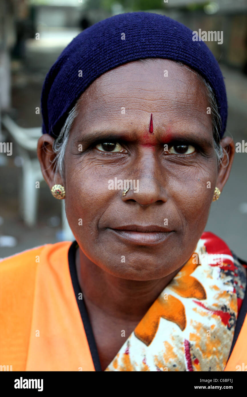 Portrait of an Indian woman wearing a hi-vis jacket; she is a street ...