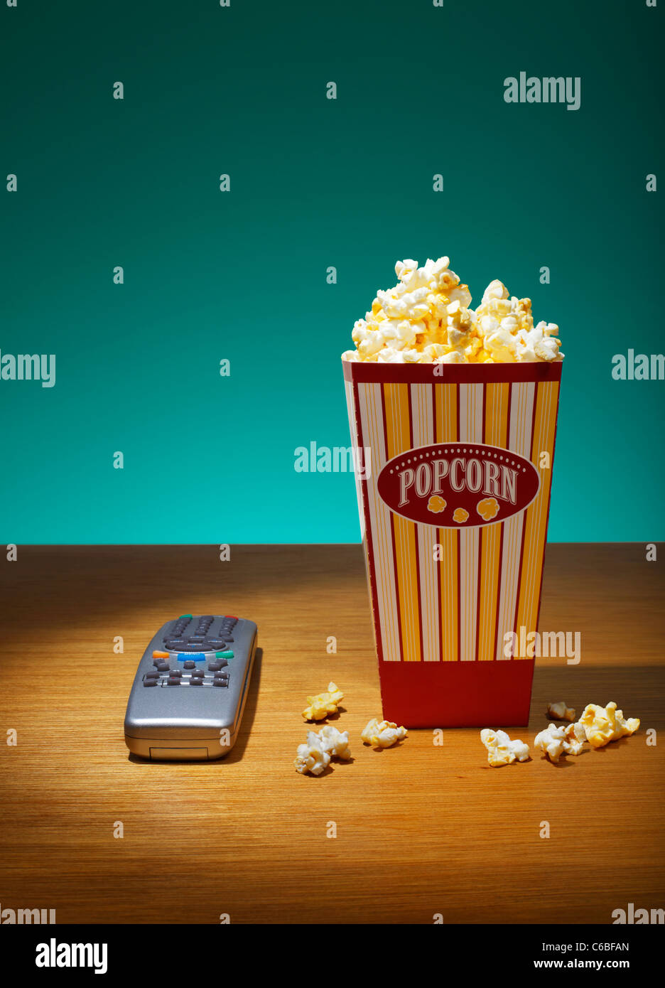 Popcorn in container and Remote Control on table Stock Photo Alamy