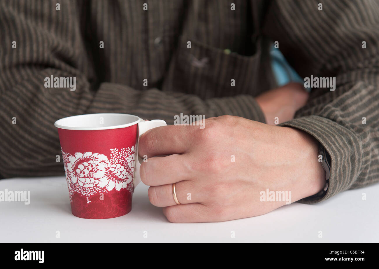 A man holding a cup of coffee in his hand. Stock Photo