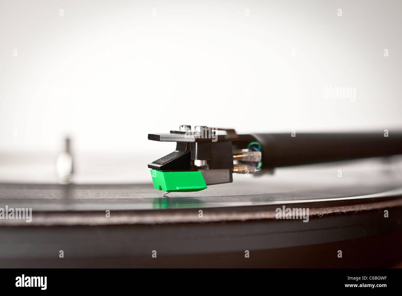 A record player and tone arm with cartridge and vinyl record Stock Photo
